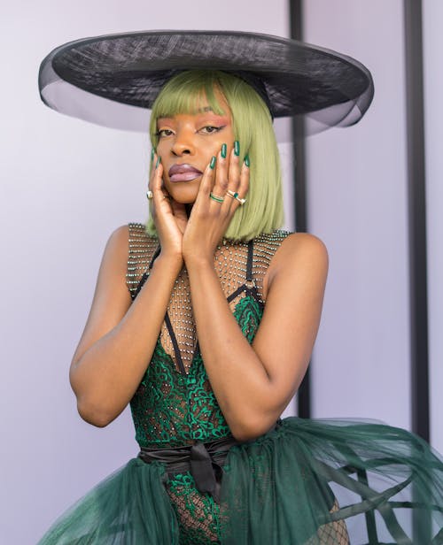 A Woman in Black and Green Cocktail Dress Wearing Black Hat