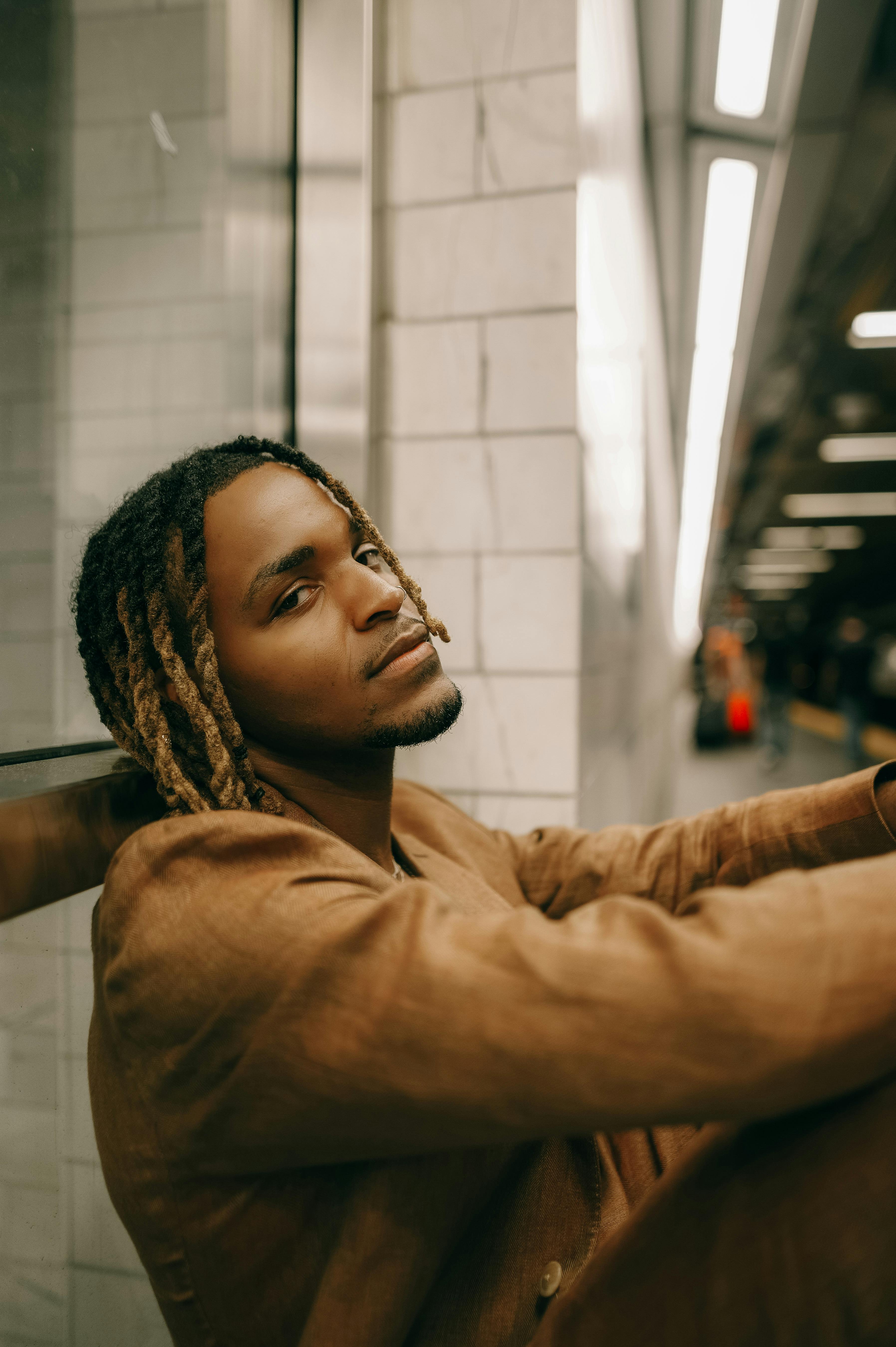 portrait of a young fashionable man sitting on a platform