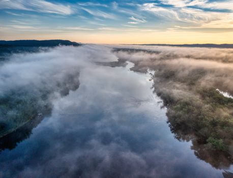 Stunning aerial view of a foggy river landscape in Trevino, Wisconsin at sunrise.