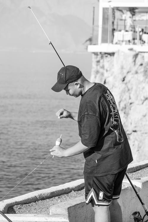 A Man in Black T-shirt Fishing on Sea