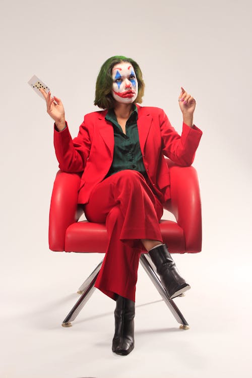 A Man with Face Paint Sitting on a Chair