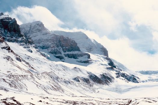 A stunning view of snow-covered mountains and clouds in Banff National Park, perfect for winter and travel themes.
