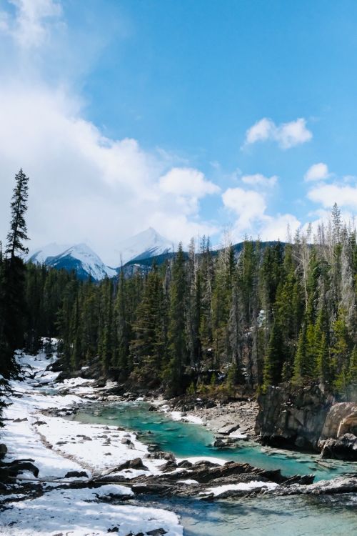 Free Discover the serene beauty of a turquoise river amidst snow-capped mountains in Banff National Park. Stock Photo