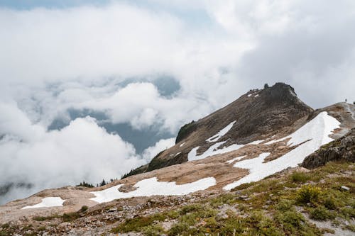 Snow on Mountainside Under White Clouds