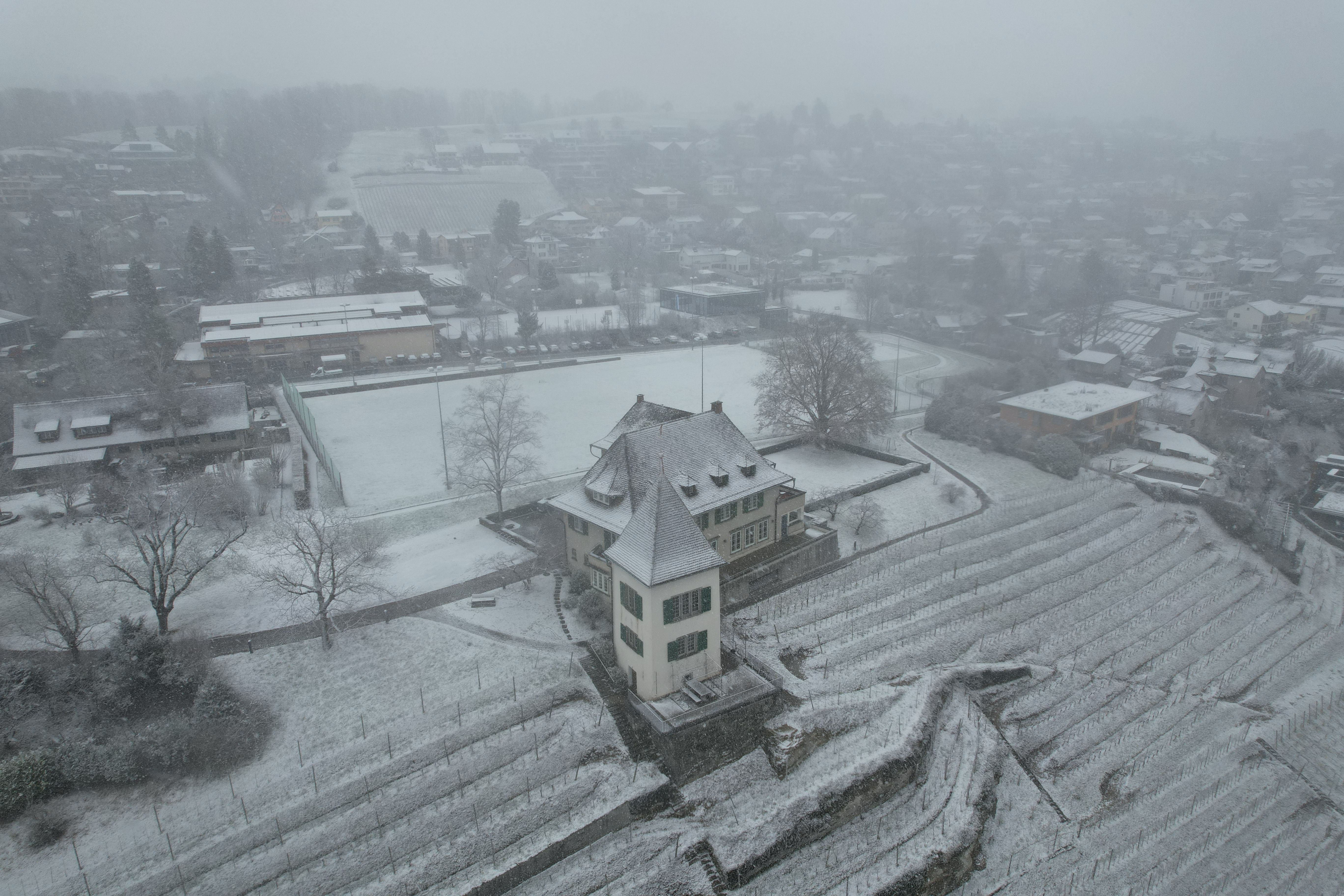 A serene aerial shot of snowy Erlenbach, showcasing architecture and landscape.