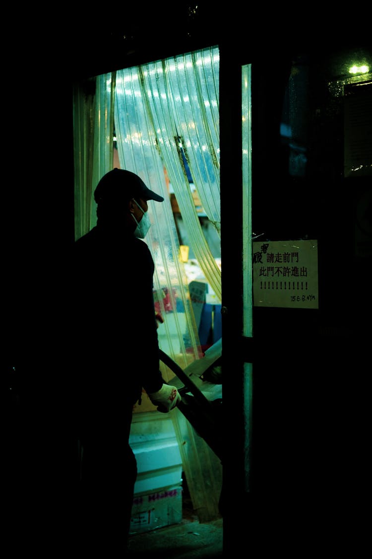 Man Walking Through Door With Trashcan