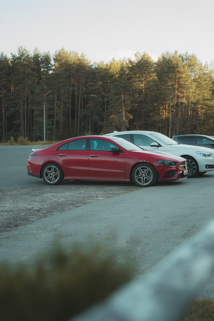 A Red Sedan Parked Beside A White Car