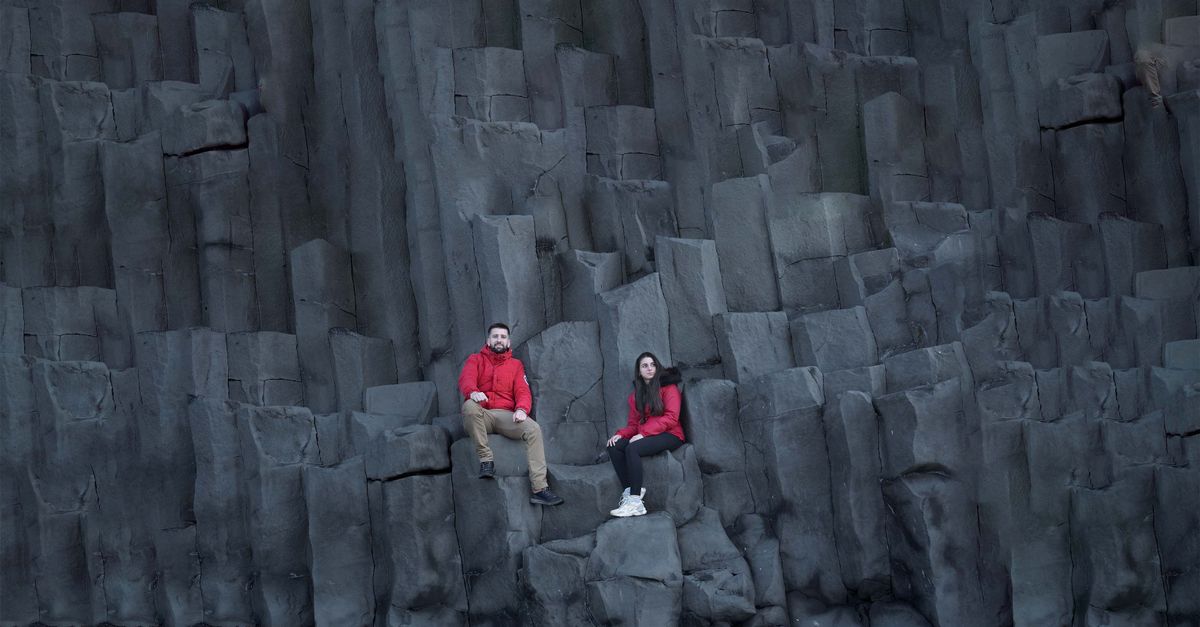 Basalt Sitting Rocks Couple Sitting on Basalt Rock Formation on Reynisfjara Beach in Iceland ...