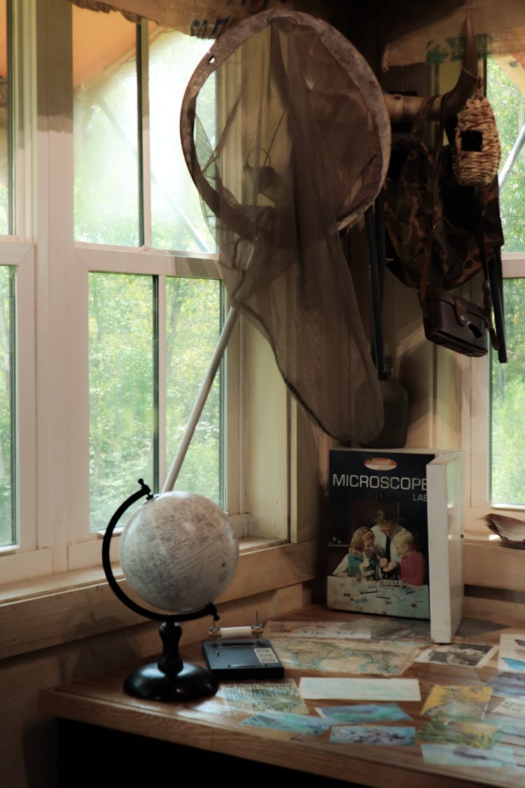 Desk With A Globe And Postcards In A Window Corner