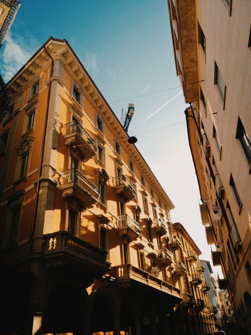 Free Elegant Italian building under a clear blue sky, featuring intricate balconies. Stock Photo