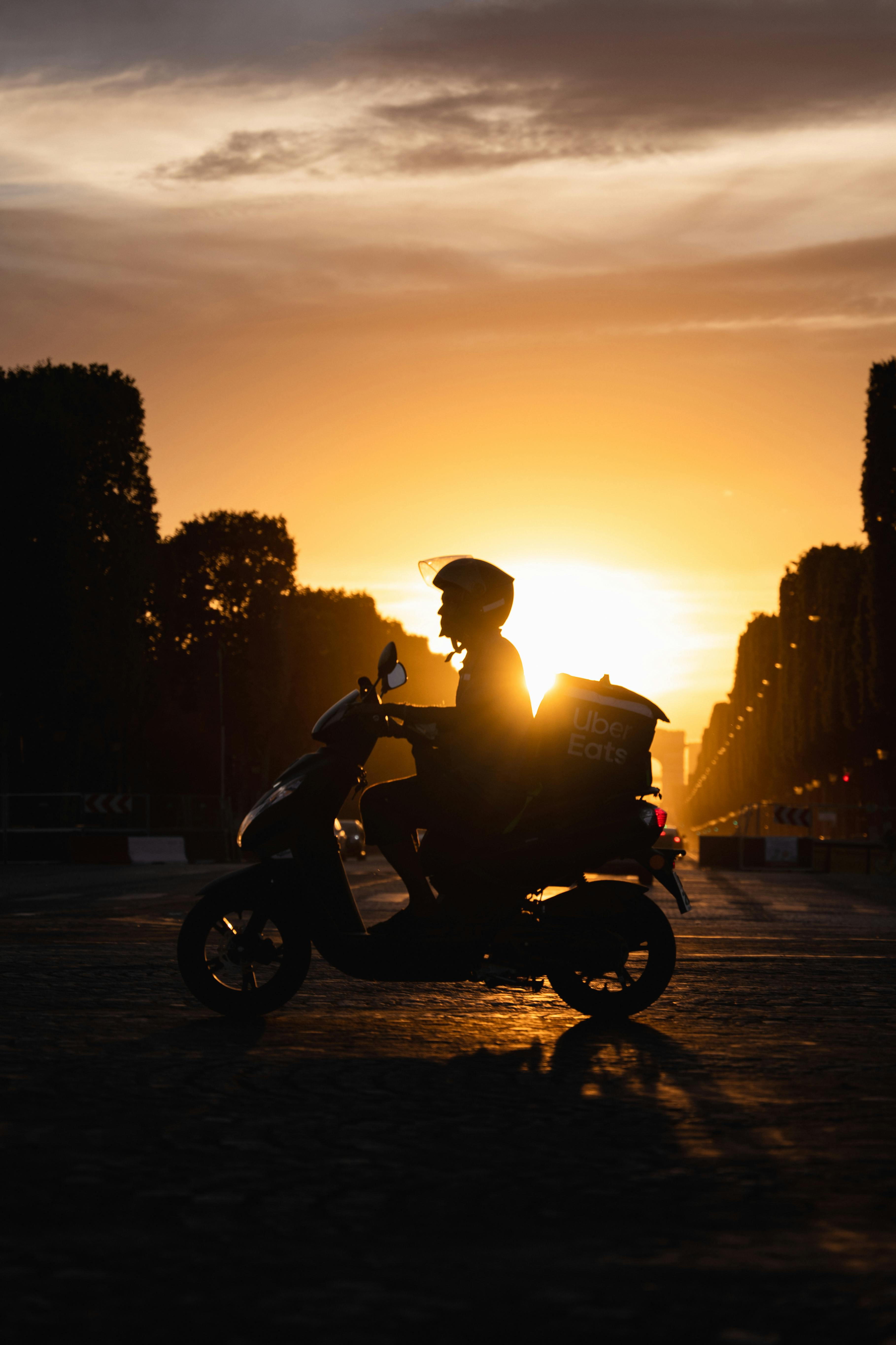 silhouette of a man riding a motorcycle during sunset