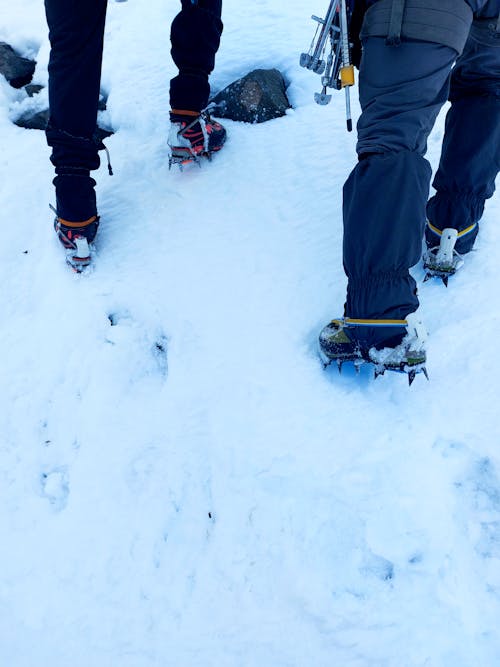 Legs of People Hiking in Snow in Mountains