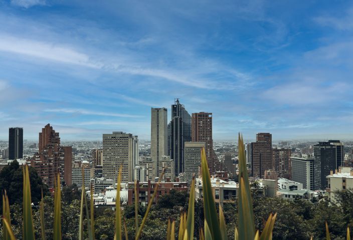 A picturesque view of Bogotá's skyline featuring modern skyscrapers against a bright blue sky.