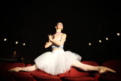 Photograph of a Ballerina on Red Seats