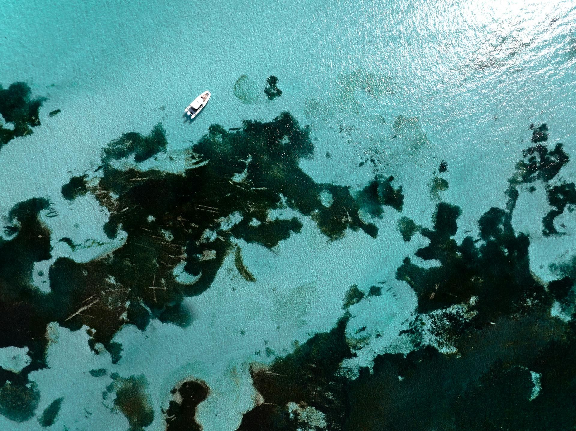 Aerial shot of a motorboat floating on the clear, turquoise waters of Rottnest Island, Australia.