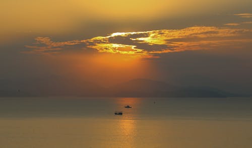 Silhouette of Boats on the Sea during Sunset