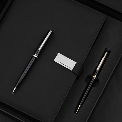Black textured notebook with two slim pens — photo by The Glorious Studio on Pexels