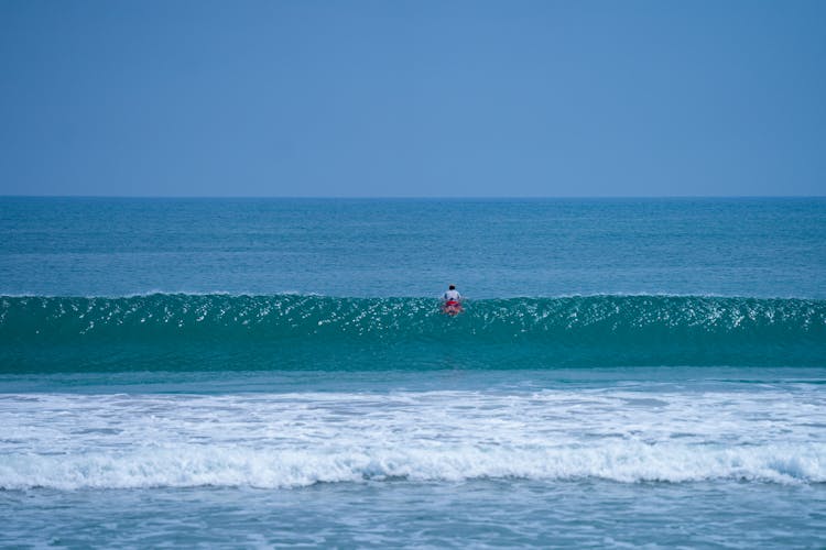 A Person Surfing Alone In The Ocean 