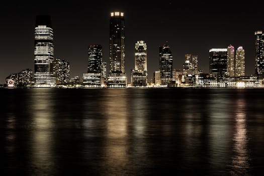 Stunning nighttime view of illuminated city skyline reflecting on calm waters.