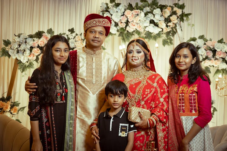 Bride And Groom Wearing A Traditional Wedding Clothes Posing With Their Family