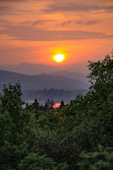 夏季，可以看到郁郁葱葱的青山和树木间充满活力的日落景色