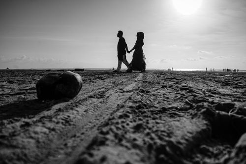 Free Black and white silhouette of a couple walking on Cox's Bazar beach, capturing love and connection. Stock Photo