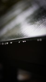 Artistic close-up of raindrops with selective focus on a surface.