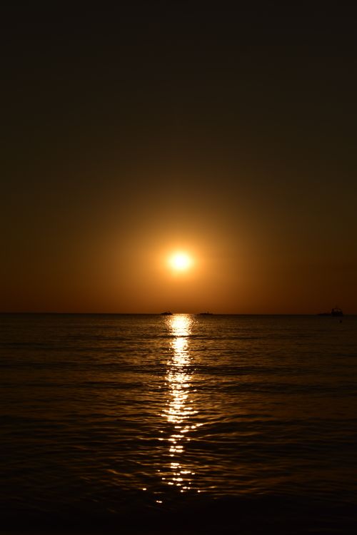 Free Beautiful sunset over calm ocean, creating a tranquil and warm ambiance. Stock Photo