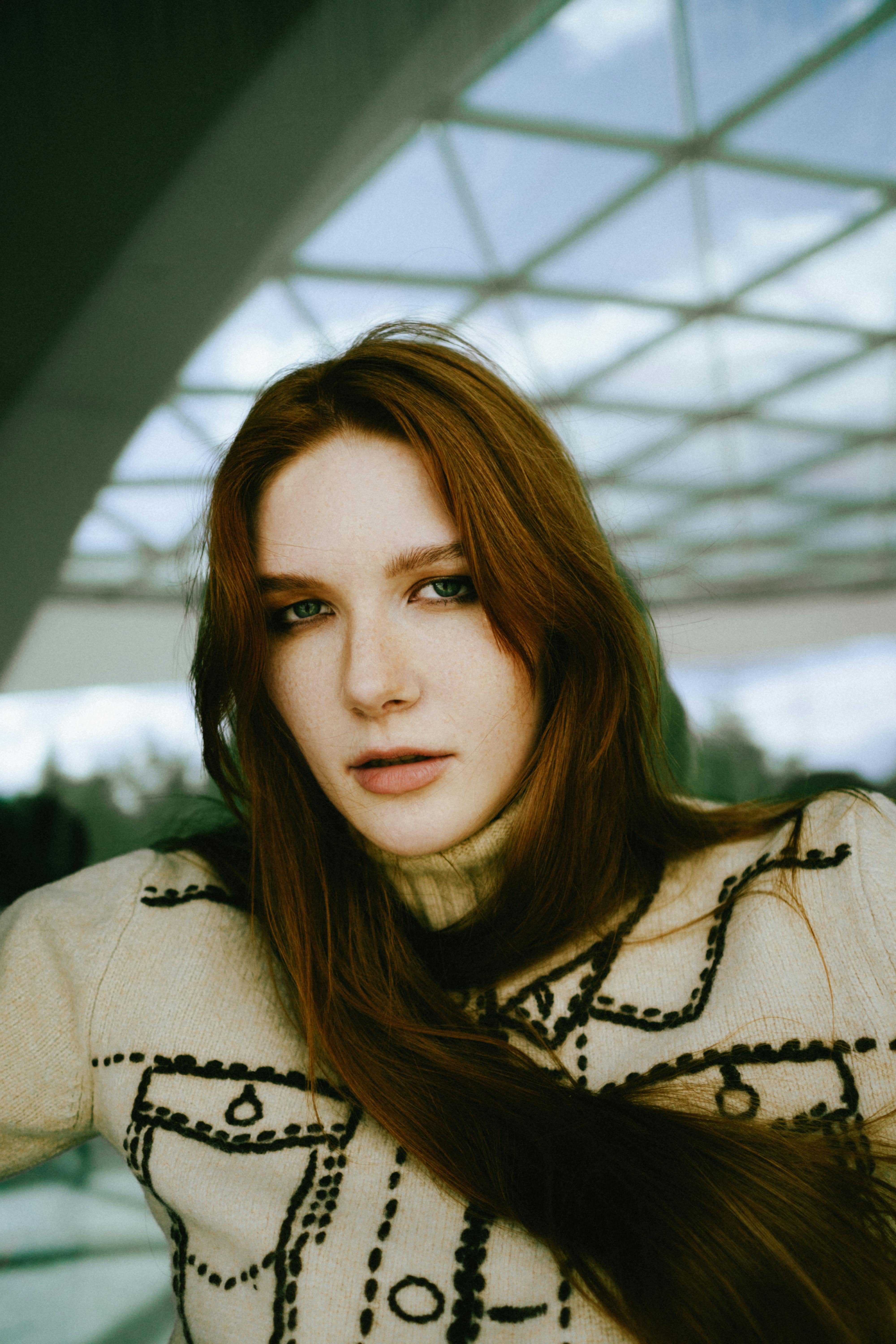 Stunning portrait of a woman wearing a stylish, geometric-patterned sweater indoors.