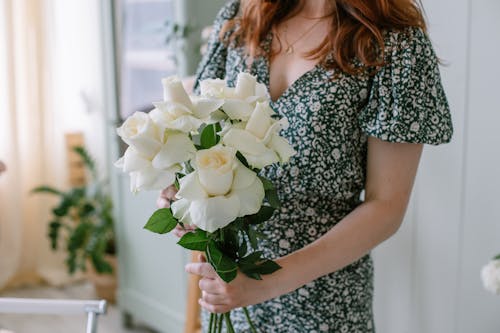 Woman in Floral Dress Holding White Roses