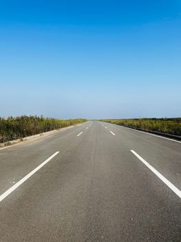Straight open road under a clear blue sky in Lvjuhe Town, Tianjin.