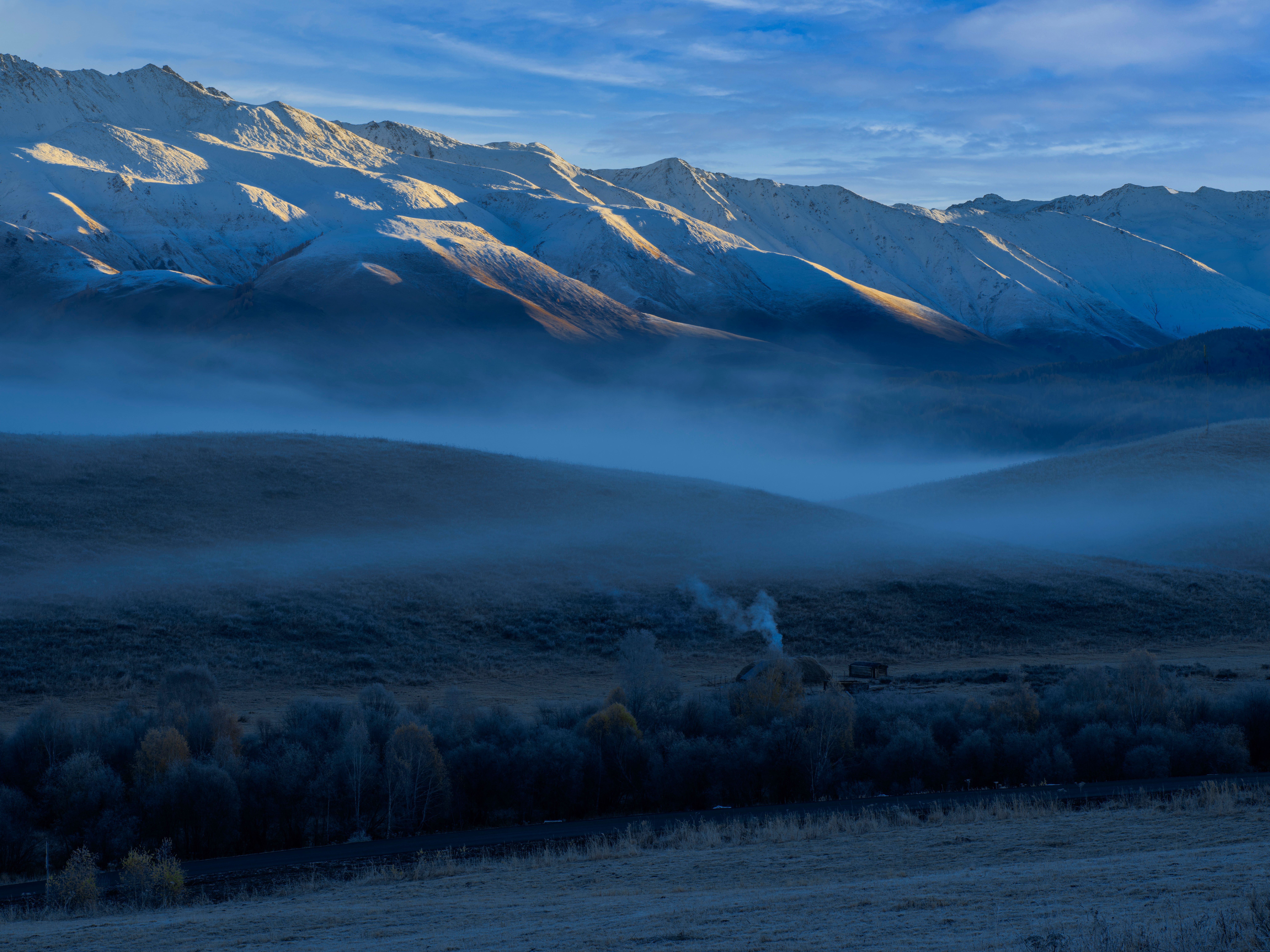 A Field with Trees Near Snow Covered Mountains Under Evening Sky · Free ...