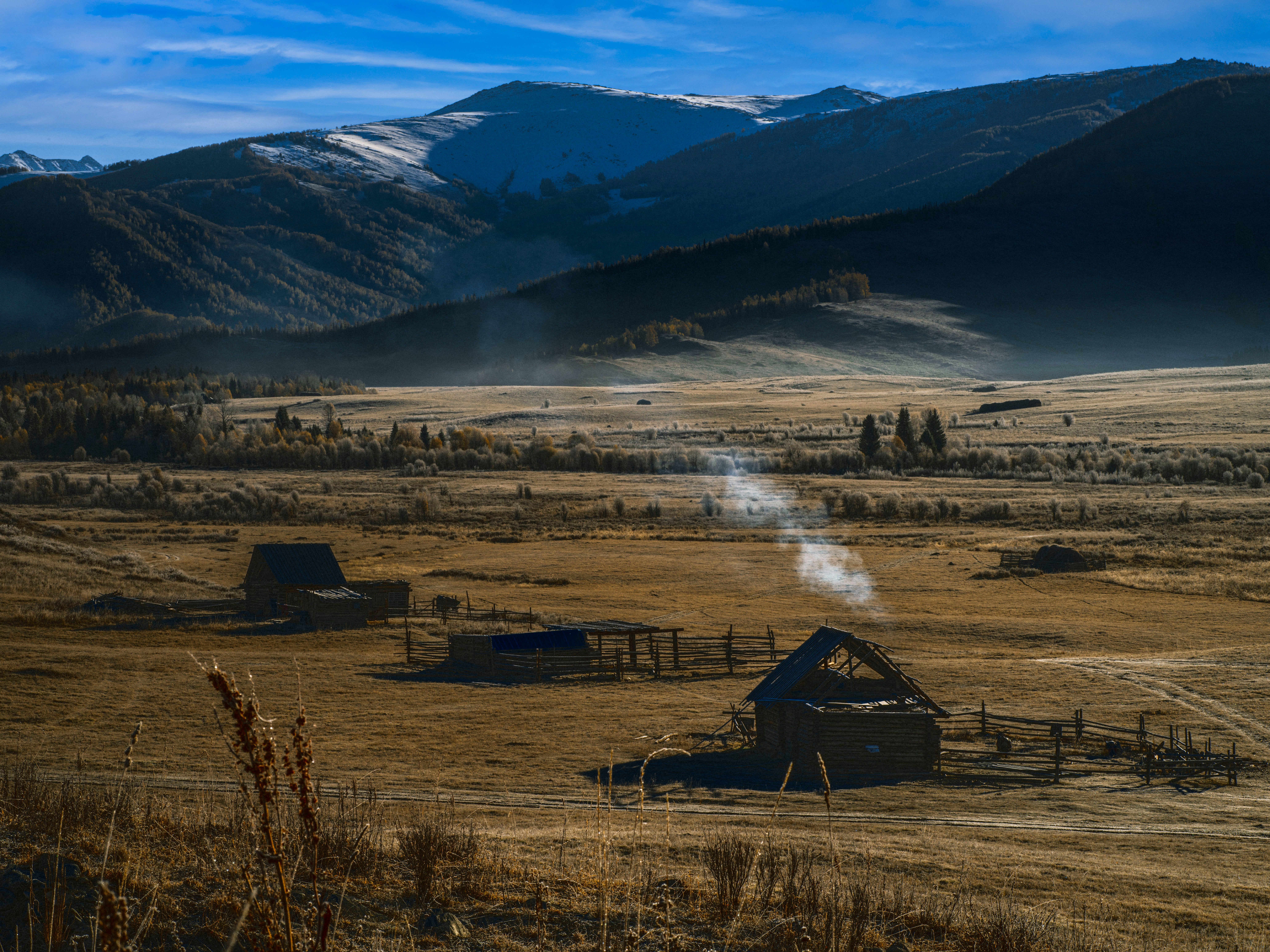 Brown Wooden Houses on Green Grass Field Near Mountain · Free Stock Photo