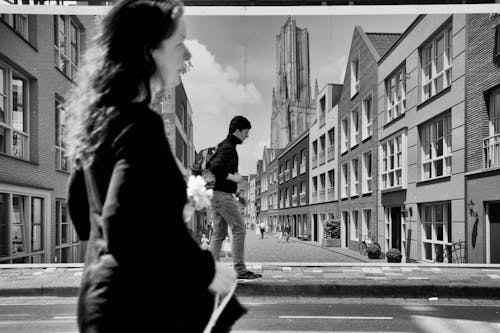 Grayscale Photo of Woman Walking on Street