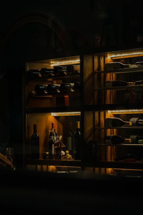 Free A stylish wine rack with various bottles showcased in cozy lighting in Mérida, Mexico. Stock Photo