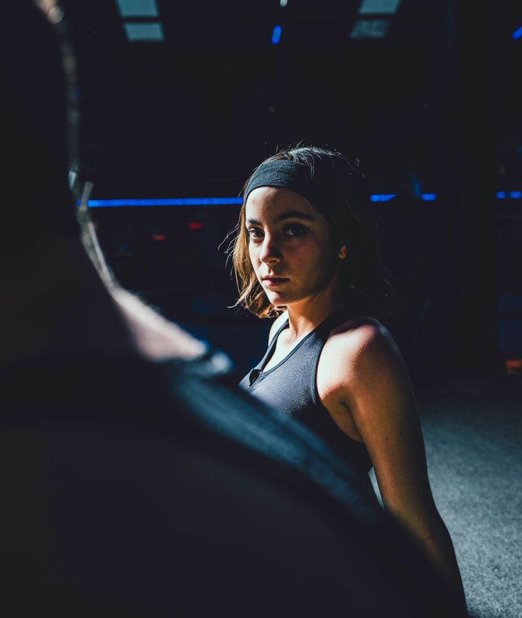 Athlete catching their breath between sets in a low-lit gym