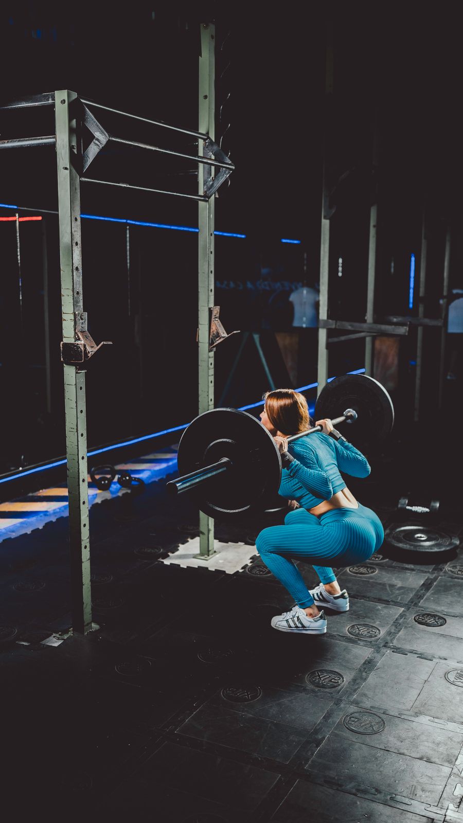 Woman performing a deep barbell squat in the gym