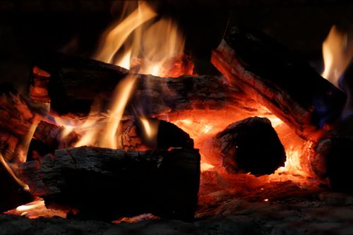 Free A detailed view of burning wood with bright flames and hot embers. Stock Photo