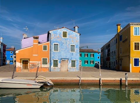 Vibrant houses reflecting in a Burano canal, capturing the essence of Italian charm.