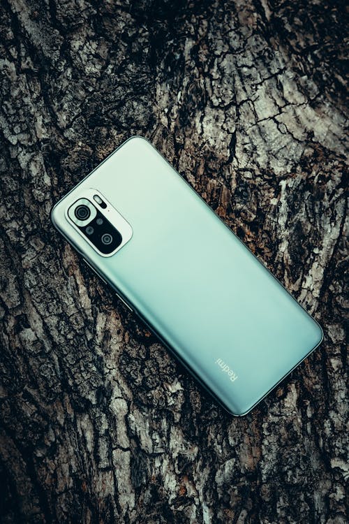 A Close-Up Shot of a Redmi Note 10 Pro on a Tree Bark