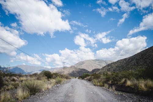 Gray Road Between Green Grass Field Under Blue Sky