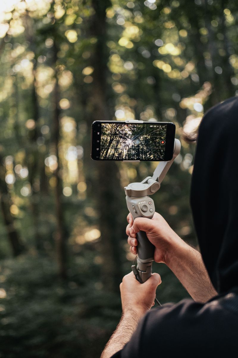 A person holding a smartphone vertically, filming a short-form video in a bright, modern indoor setting