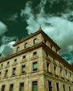 A Low Angle Shot of a Concrete Building Under the Cloudy Sky