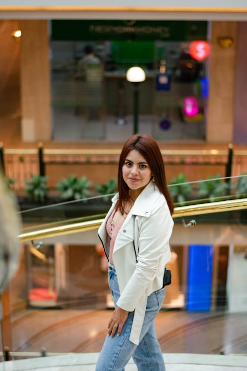 Woman in White Jacket Standing Beside Glass Railing