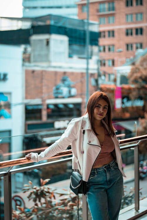 A Woman in White Jacket and Blue Denim Pants Posing