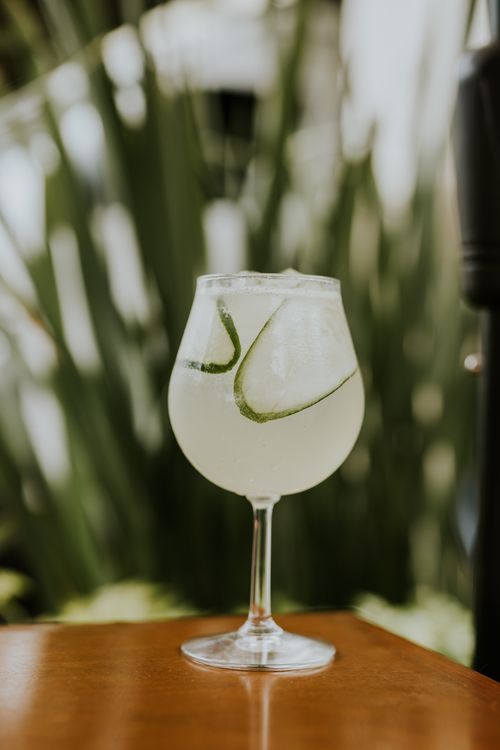 Free A chilled lime beverage served in a wine glass against a blurred green background. Stock Photo