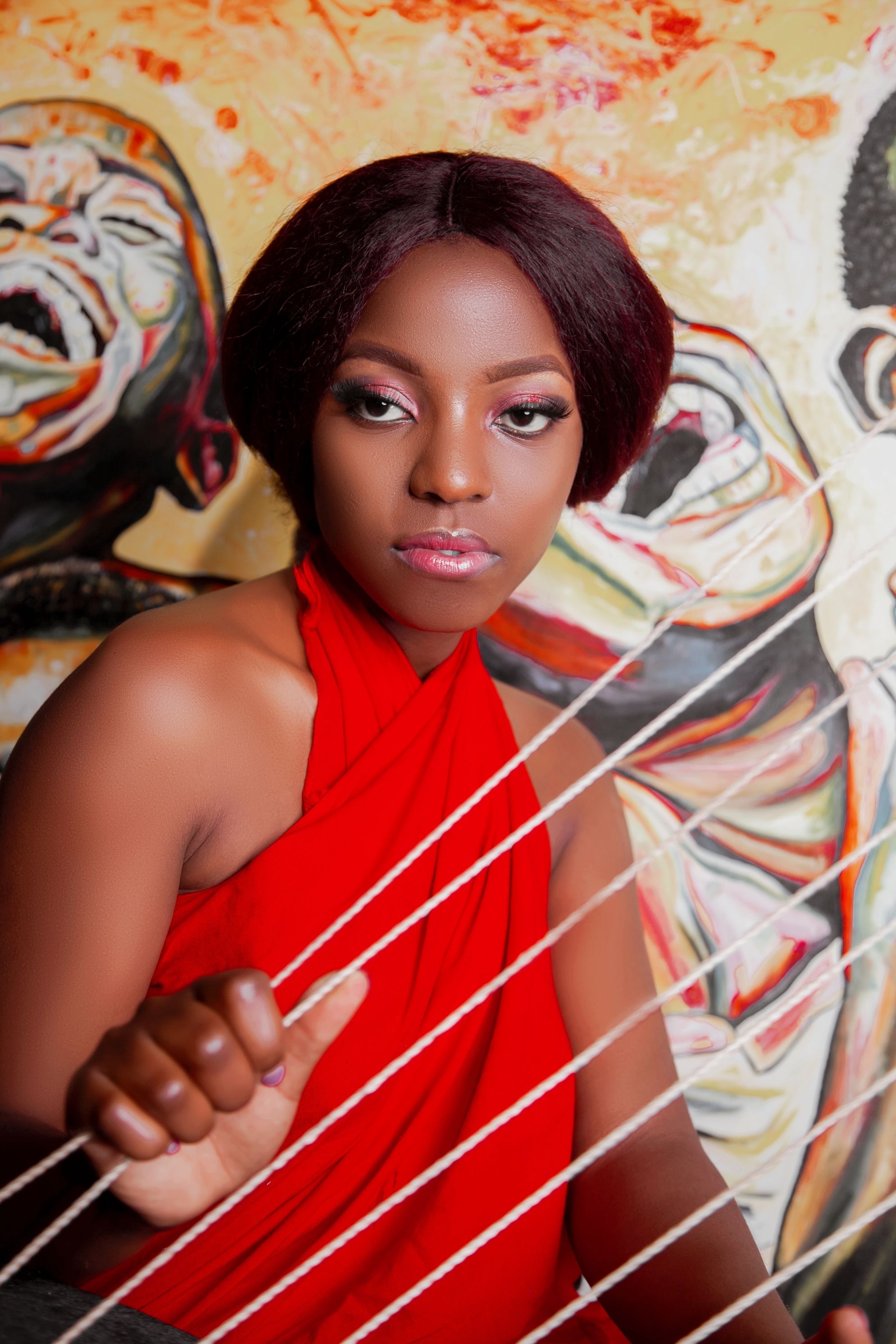 Elegant woman in red dress with expressive art background, showcasing beauty and creativity.