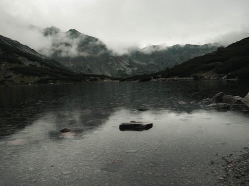 Black and Gray Rocky Mountains near Body of Water