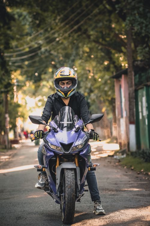 Free Young adult on a motorcycle wearing a helmet on a suburban street in Dhaka, Bangladesh. Stock Photo