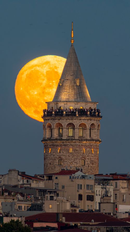 Free Stunning view of Galata Tower with a full moon in the backdrop creating a captivating evening scene. Stock Photo